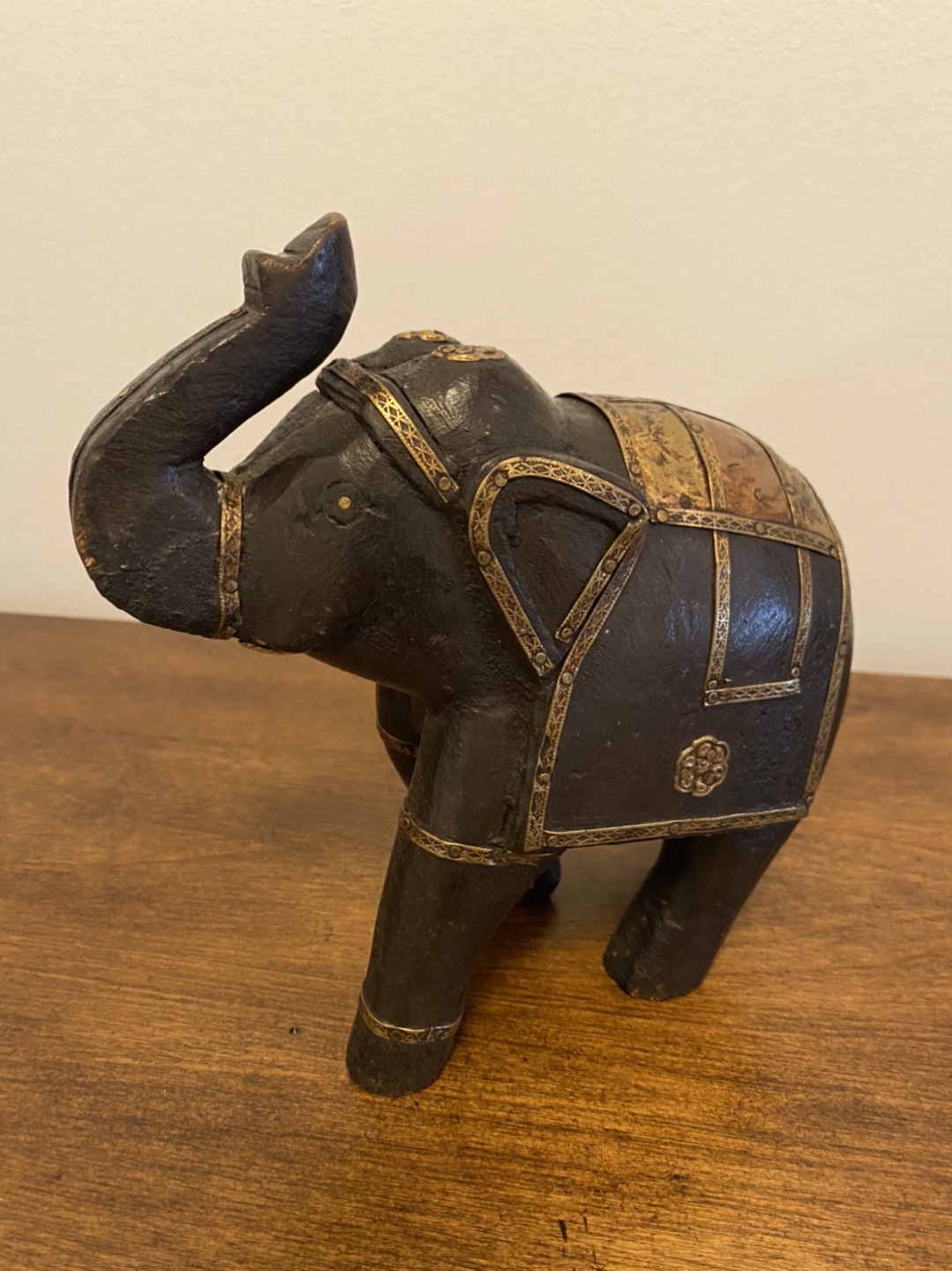 Wood elephant with gold and brass metal decorations. 