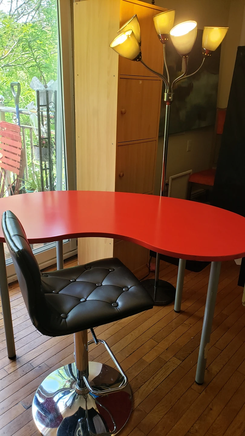 Red table in the shape of a cashew with chair