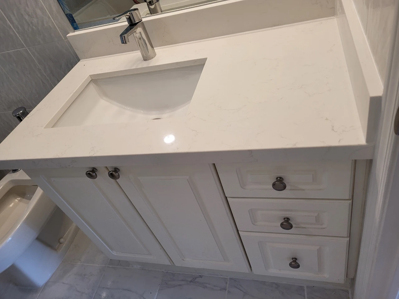 bathroom vanity, sink, faucet, countertop, and the lighting