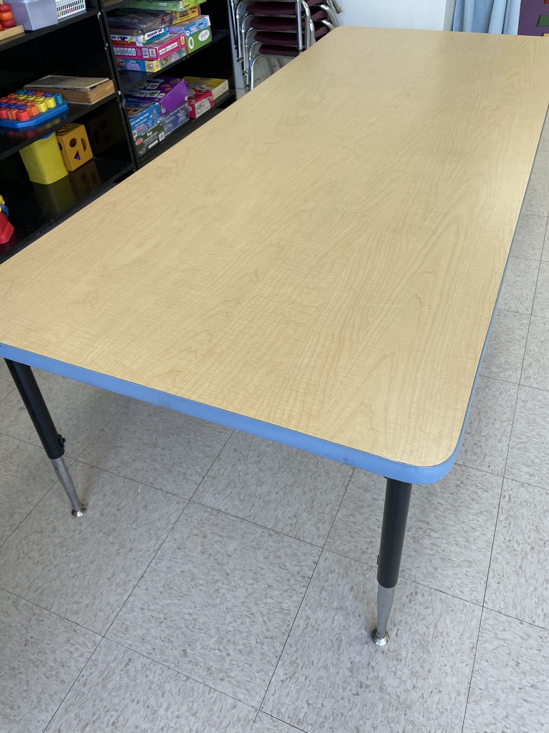 Adjustable table, rectangle maple with blue, 30”D x 72”W x 25”H.