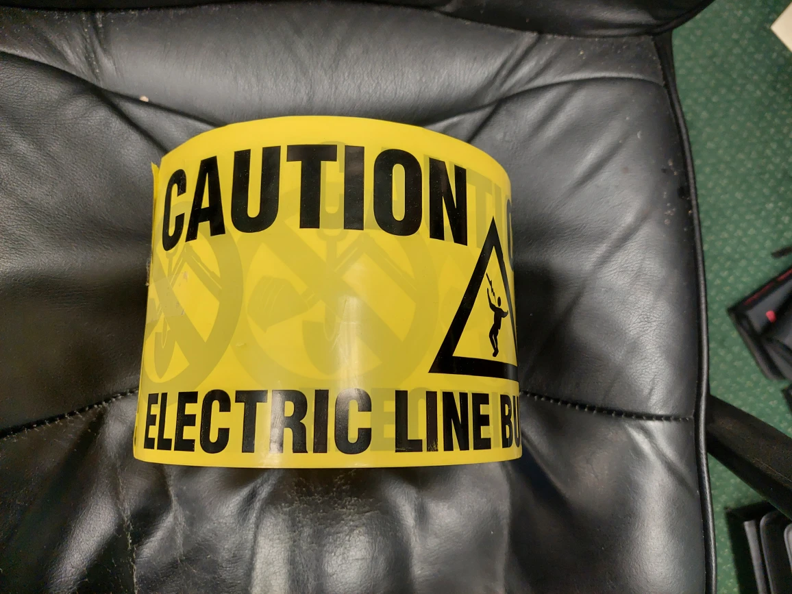 Yellow 6-in plastic Caution Electric Line Buried Below tape roll