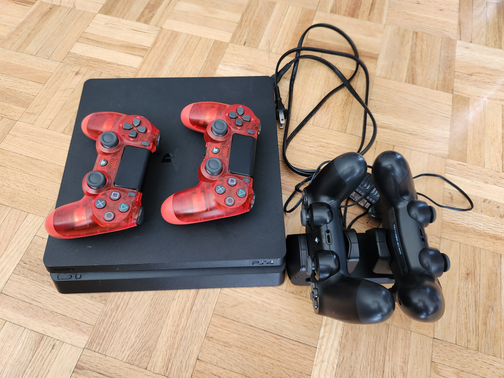PS4 with 4 controllers and charging stand.