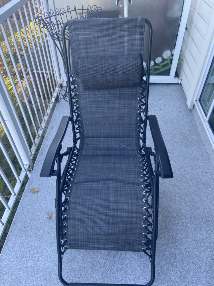 Black foldable recliner with head cushion.