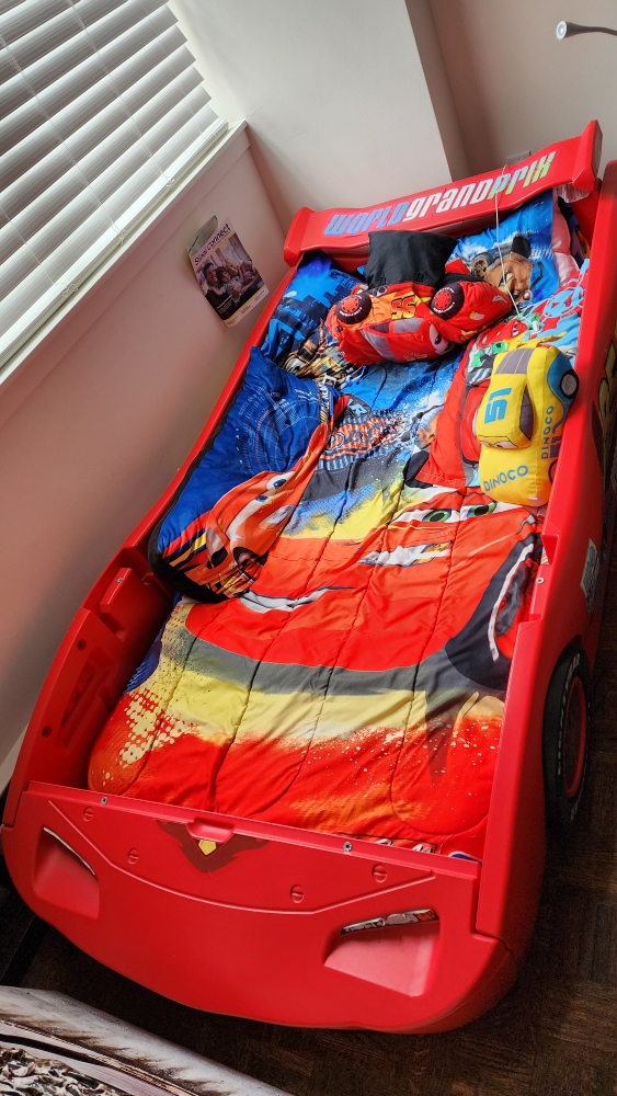Plastic kids car bed with mattress, sheets, and car pillows