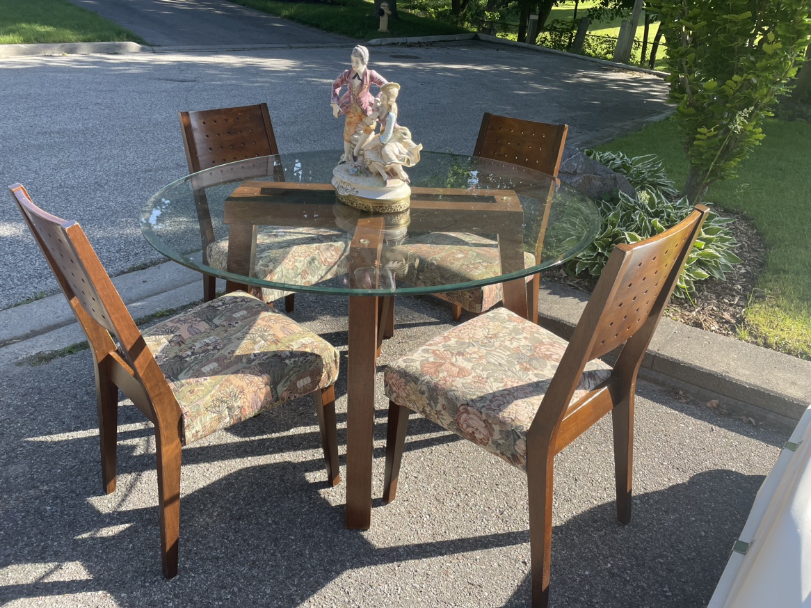 Wooden table with glass top and four chairs