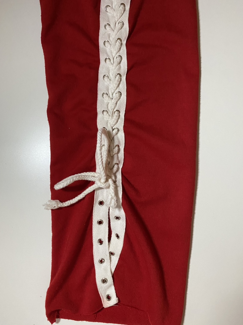 Red long sleeve shirt with white laces on sleeves image indicator(4)