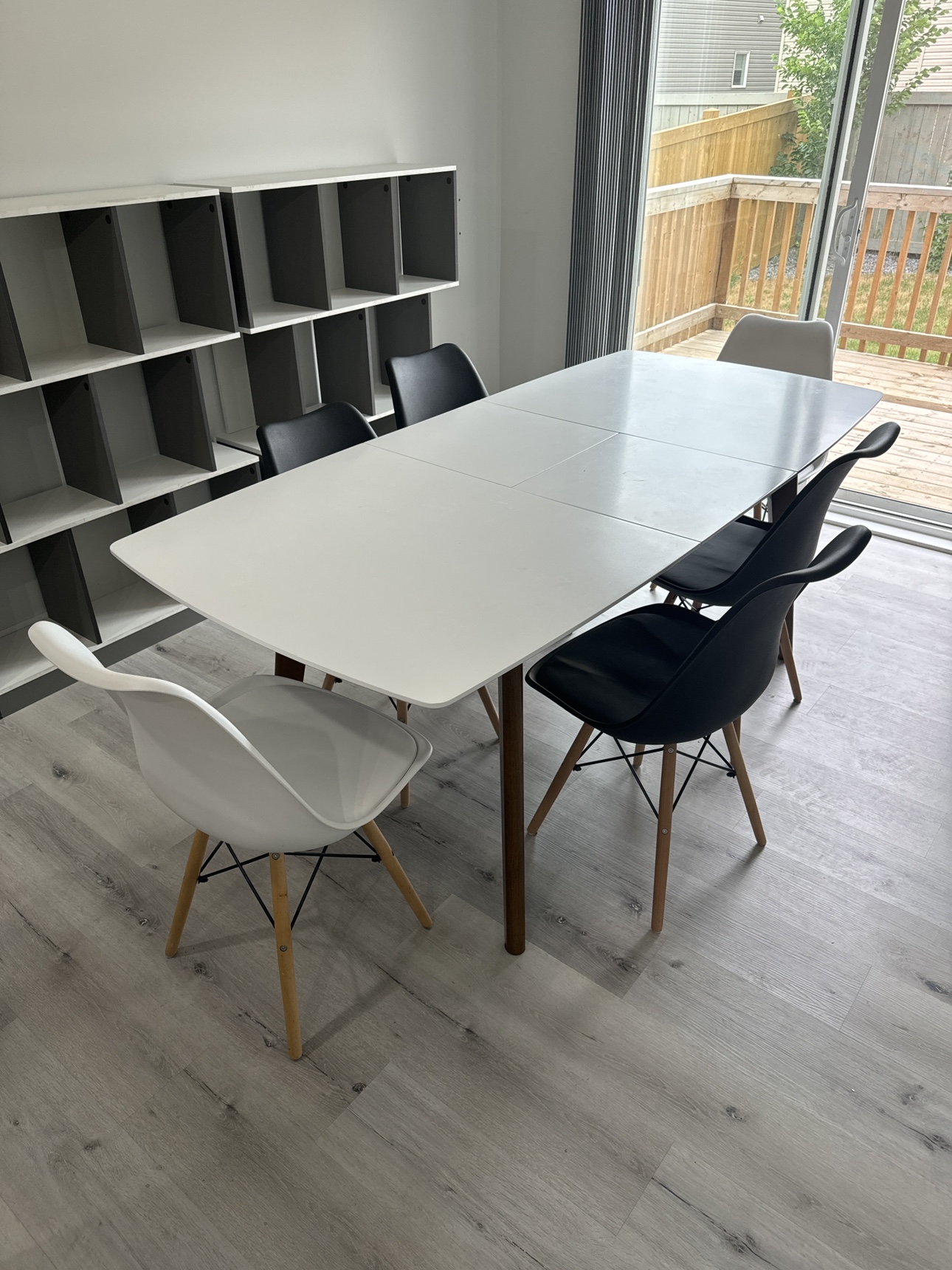 Extendable white dining room table with dark wood legs