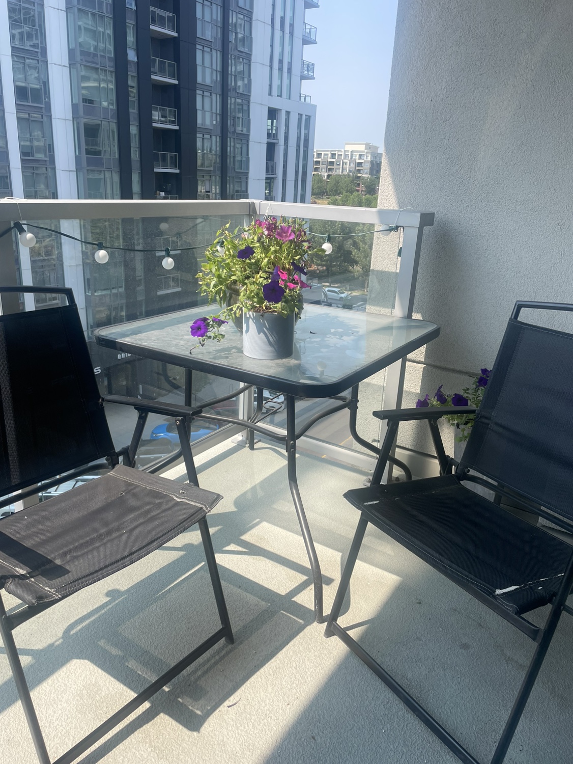 Glass patio table with 4 folding chairs